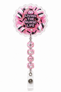 Living the Nurse Life pink decoden cream badge reel with black and white candy charms on a pure white background