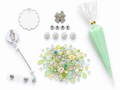 Mint clover DIY badge reel kit flatlay, shown with CARE silver letter beads and four white iridescent rhinestone beads