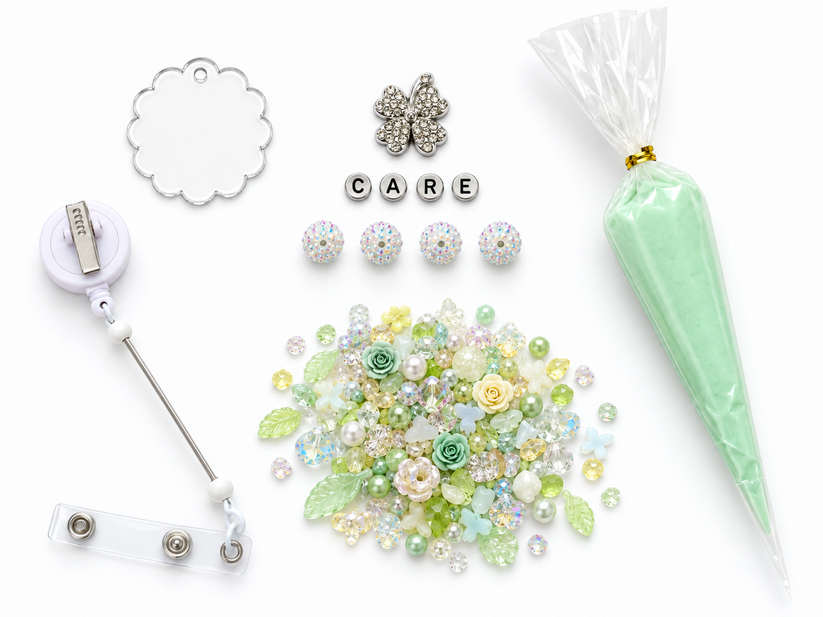 Mint clover DIY badge reel kit flatlay, shown with CARE silver letter beads and four white iridescent rhinestone beads