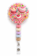 Strawberry Tea Party decoden cream badge reel with teapot, teacup, cake, fruit slices, and pastel fuzzy beads