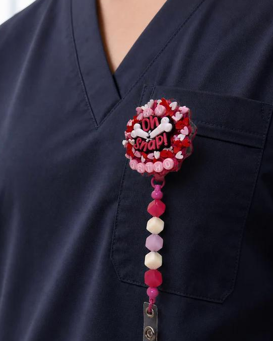 ORTHO badge reel worn on navy scrubs